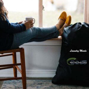 A woman sitting on the edge of a window sill with her feet up.