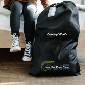 A person sitting on the ground with a laundry bag.